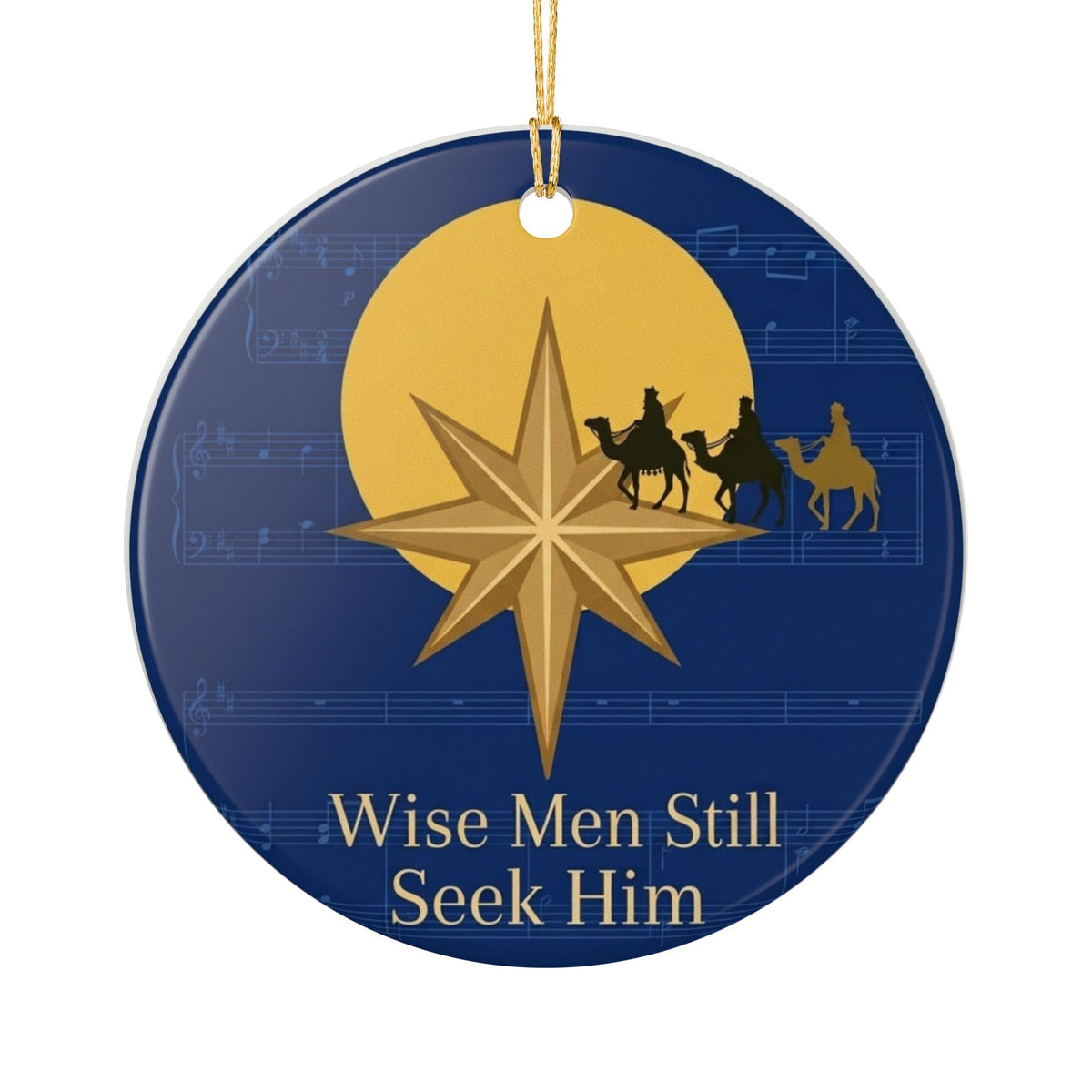 Round navy blue ceramic Christmas ornament with gold Star of Bethlehem, three wise men on camels silhouette, sheet music texture background, and gold text reading Wise Men Still Seek Him with gold hanging string