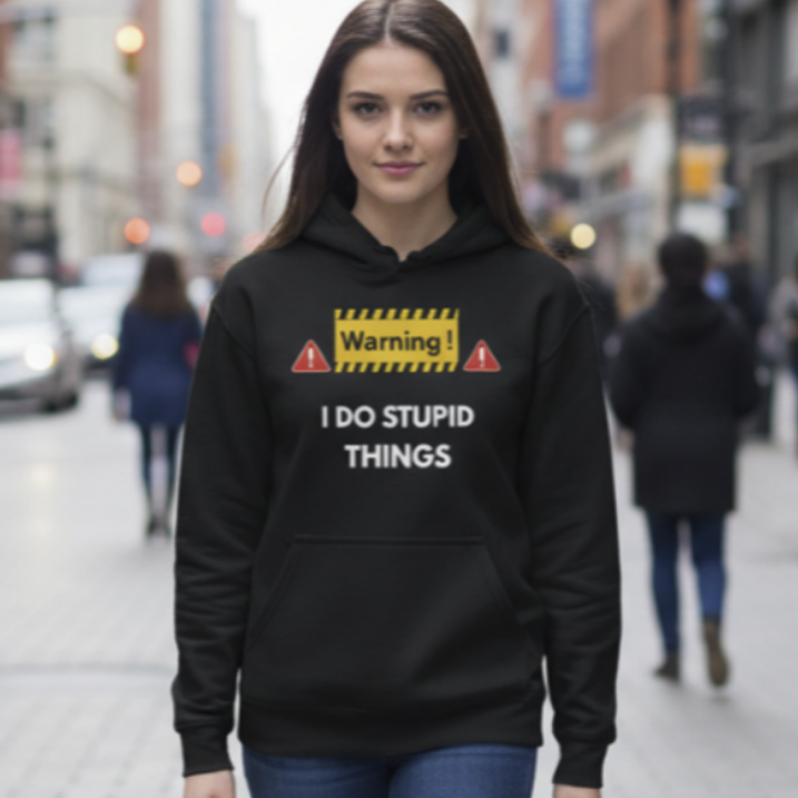 Woman wearing a black hoodie with text and graphics on a city street.