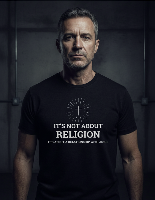 Man wearing a black t-shirt with a religious message against a dark background
